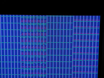 Macro photo of colorful glitched patterns on a LCD screen in 8x16 blocks, each made up of horizontal lines.