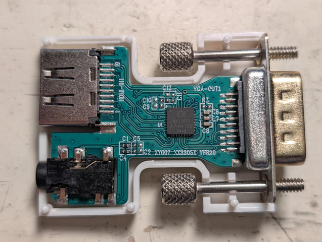 Photo of HDMI DAC with shell removed. The stereo channels lead from the DAC chip across the PCB, where C1 and C4 have black 0-ohm resistors leading to the headphone pins, and C2 and C5 are unpopulated footprints leading to ground.